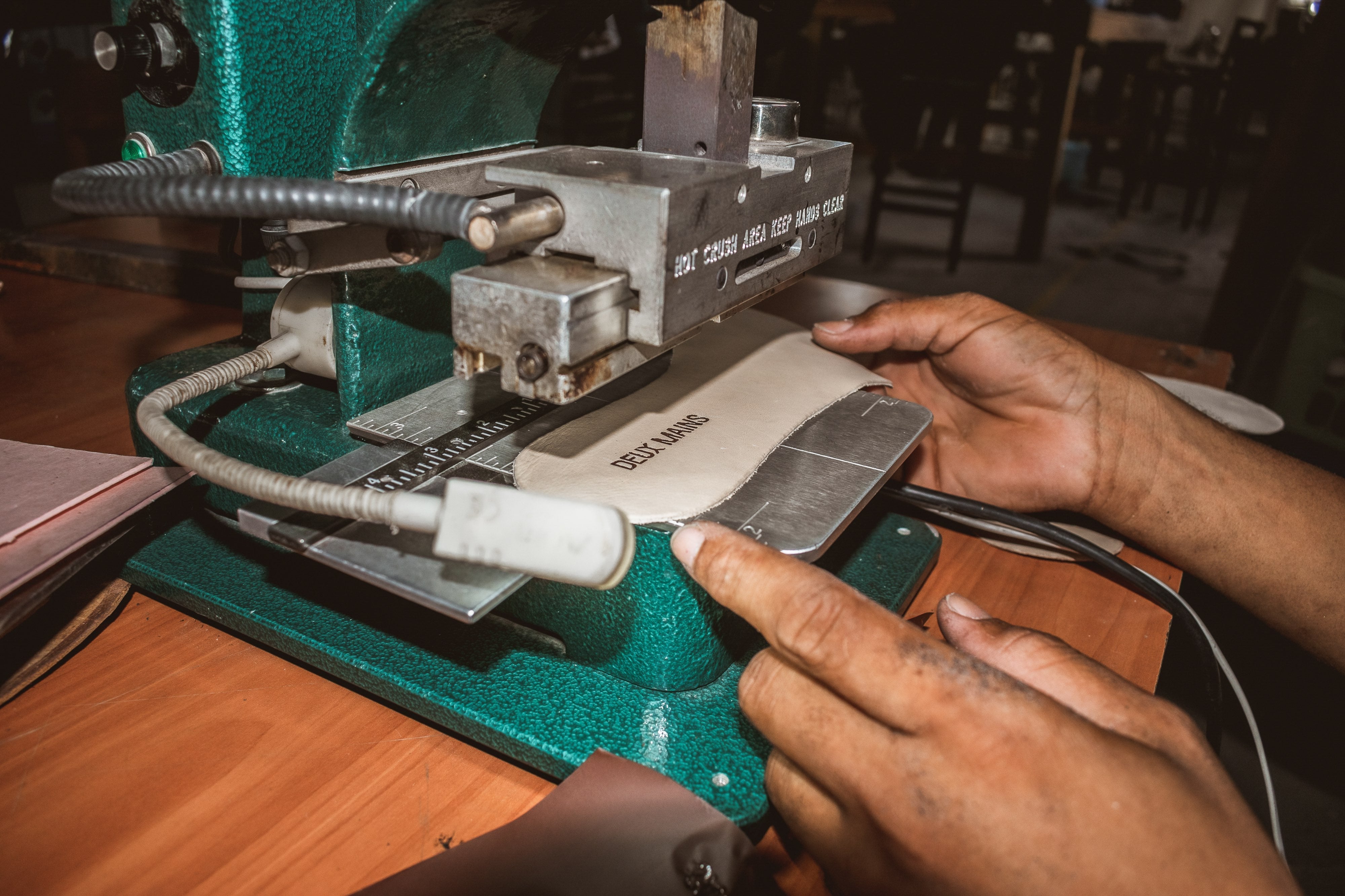 factory machine worker creating shoes with our branding.