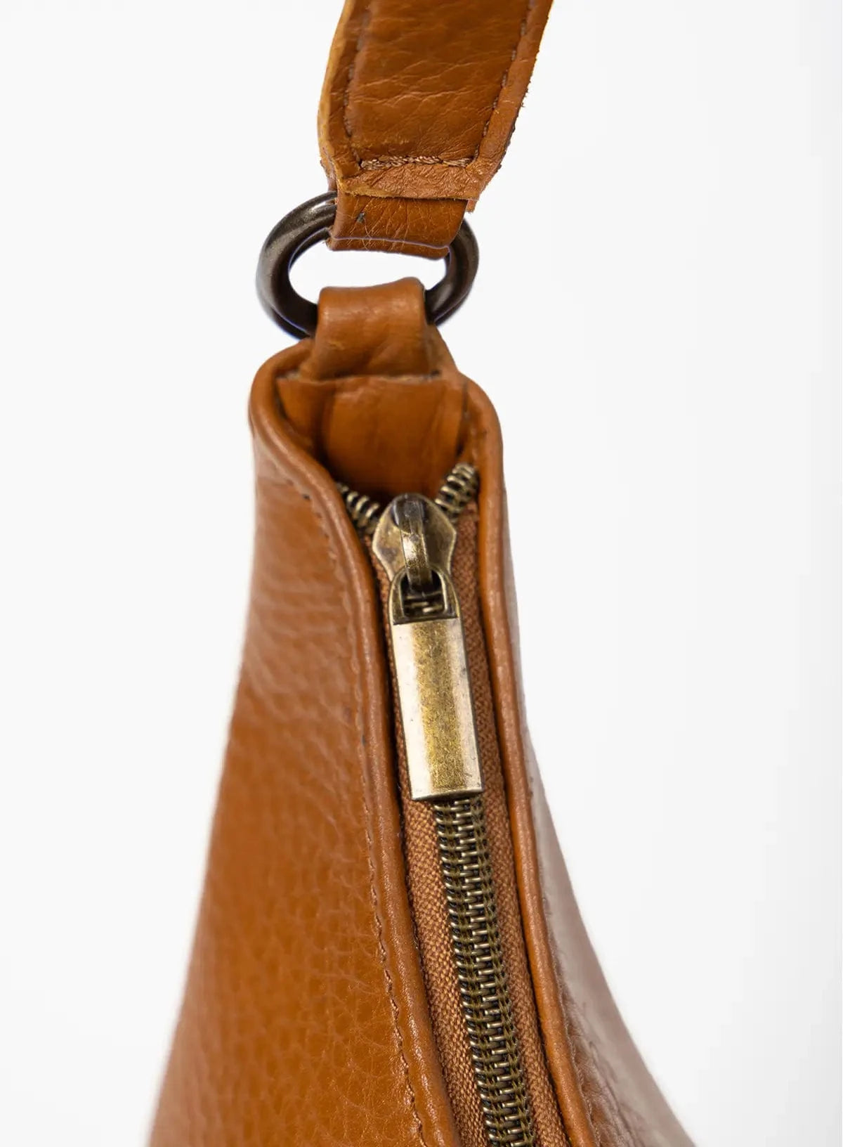 Close-up of a honey leather bag with a gold zipper on a white background