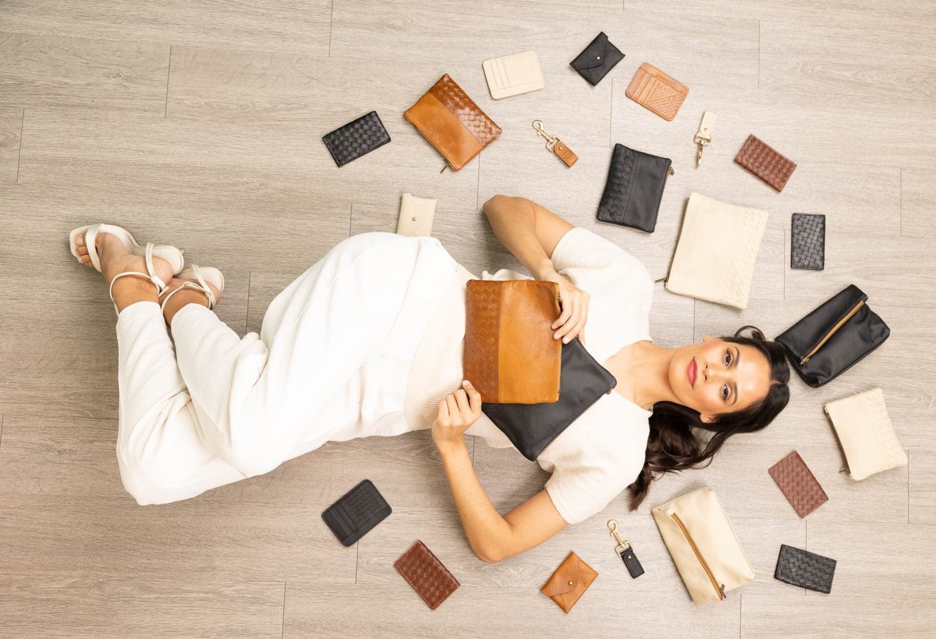 Woman surrounded by affordable leather accessories.