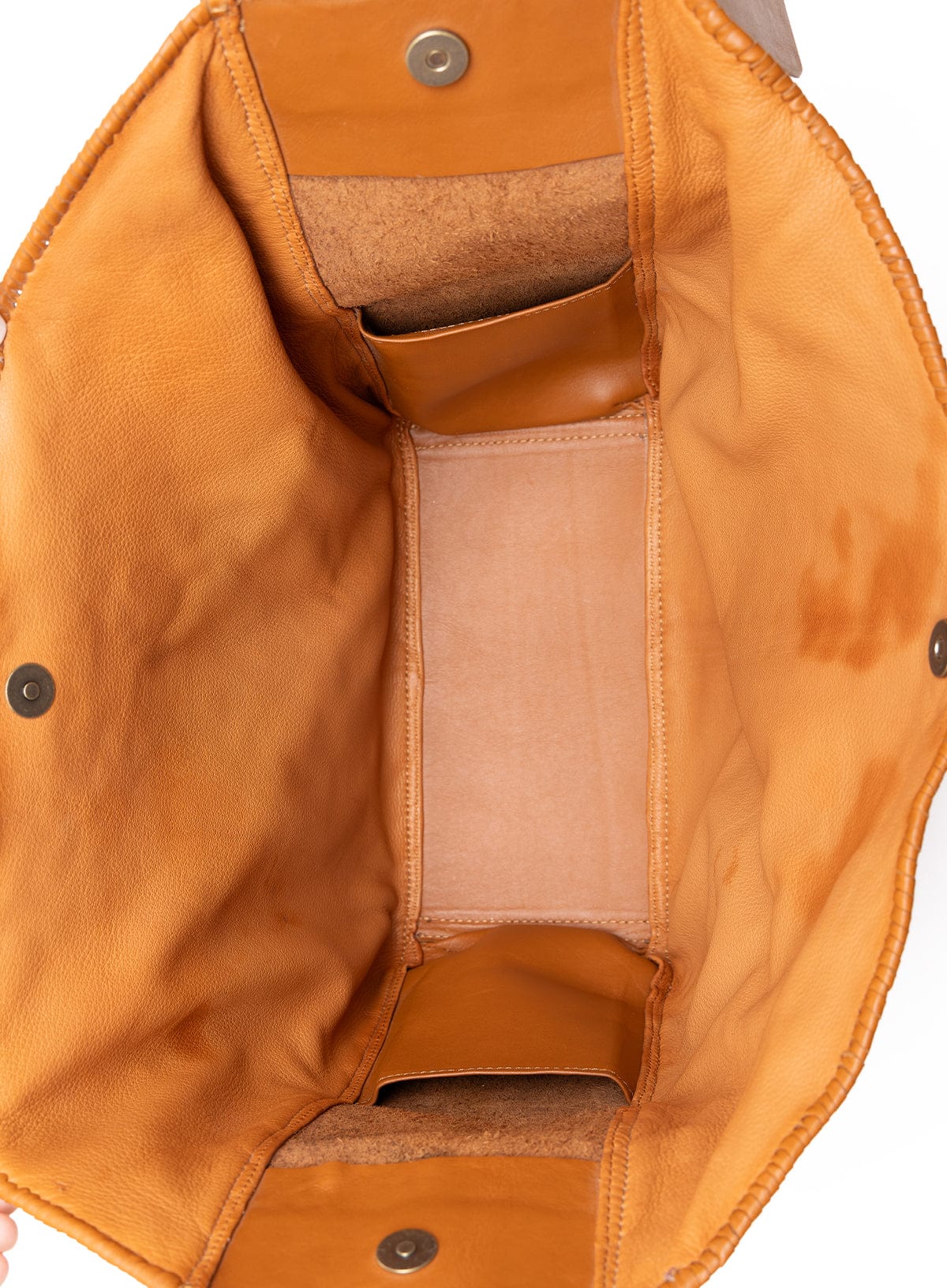 Close-up of a brown leather bag with visible stitching and hardware.
