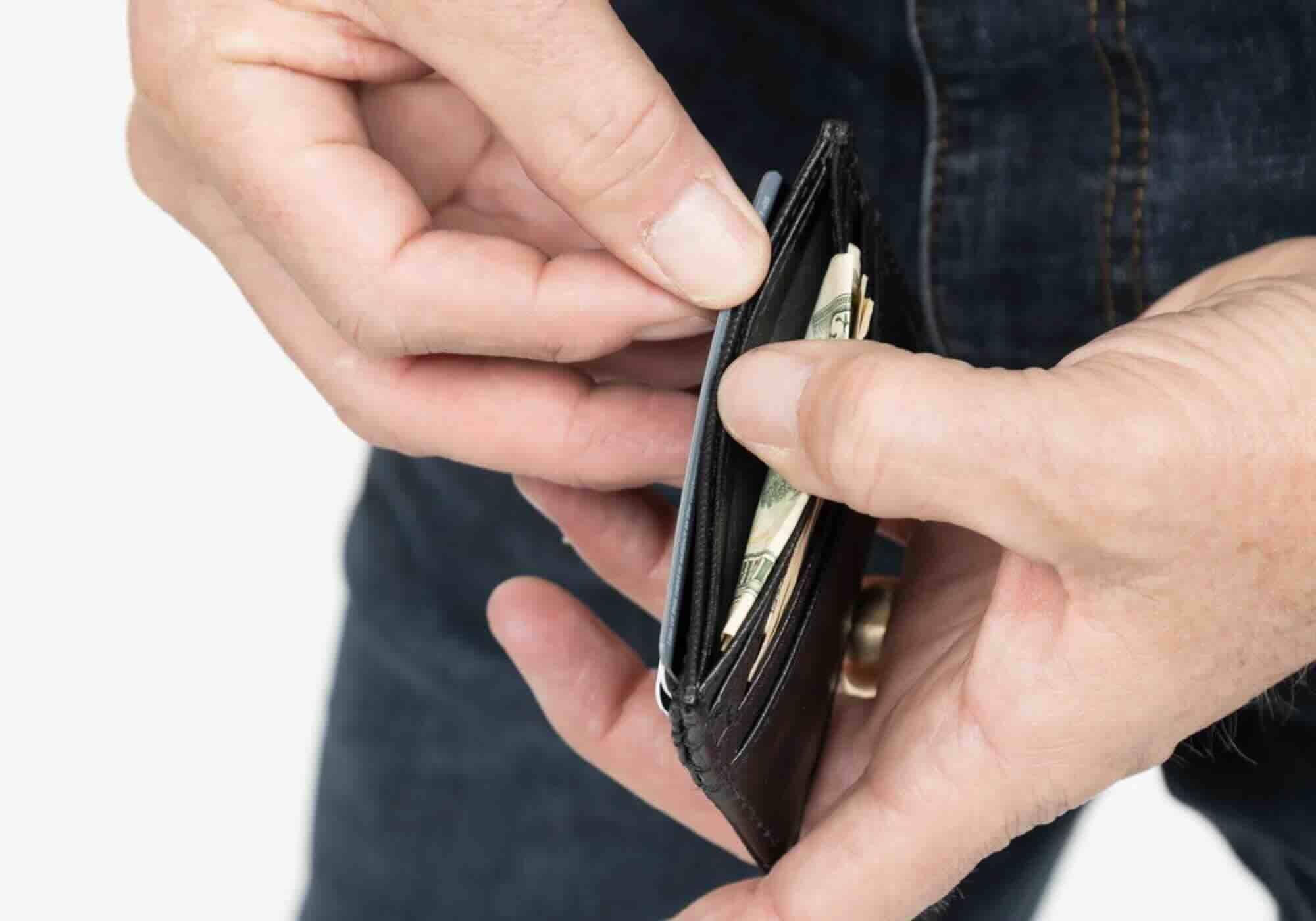 Close-up of hands holding a card holder with money and cards