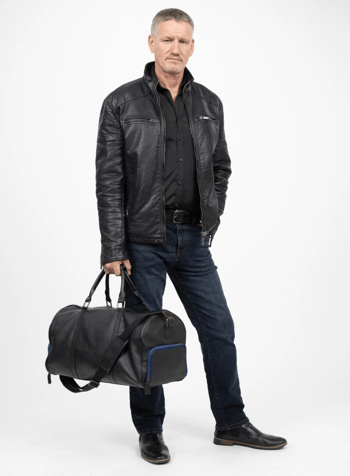 Man holding a black duffel bag against a white background