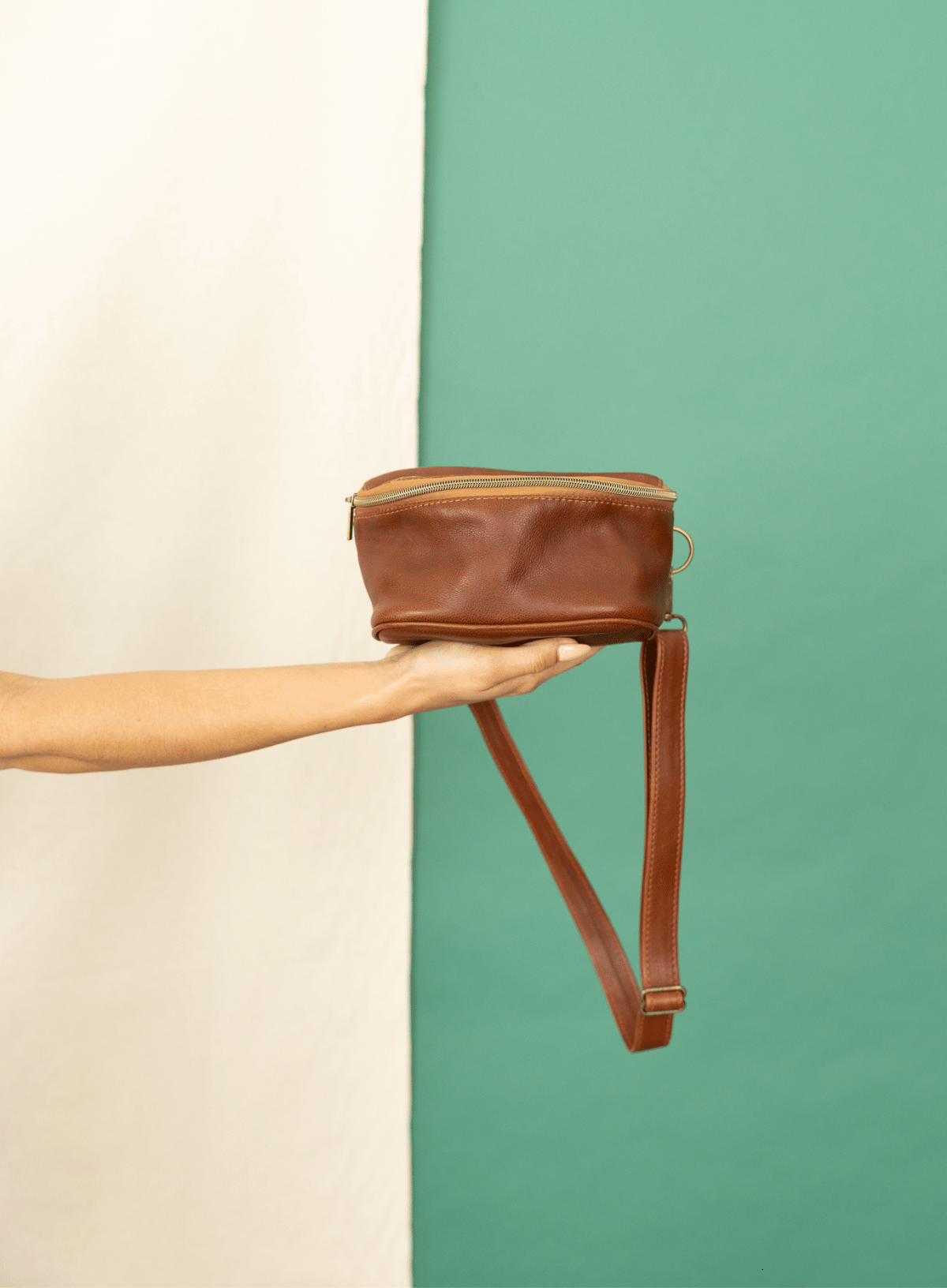 Hip bag in mahogany from the fall/winter collection held by model.