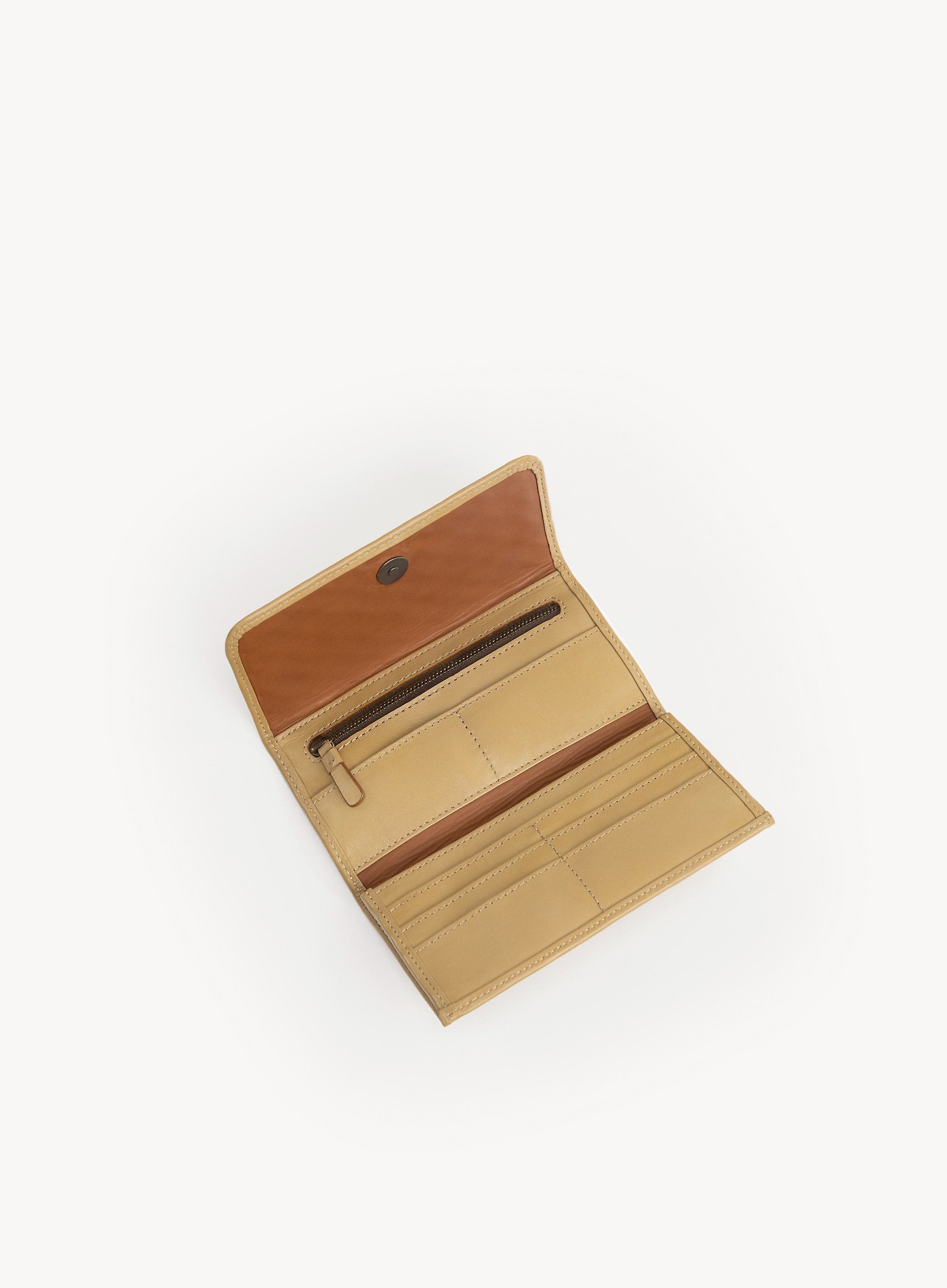Interior of a butter yellow wallet with woven pattern on a white background