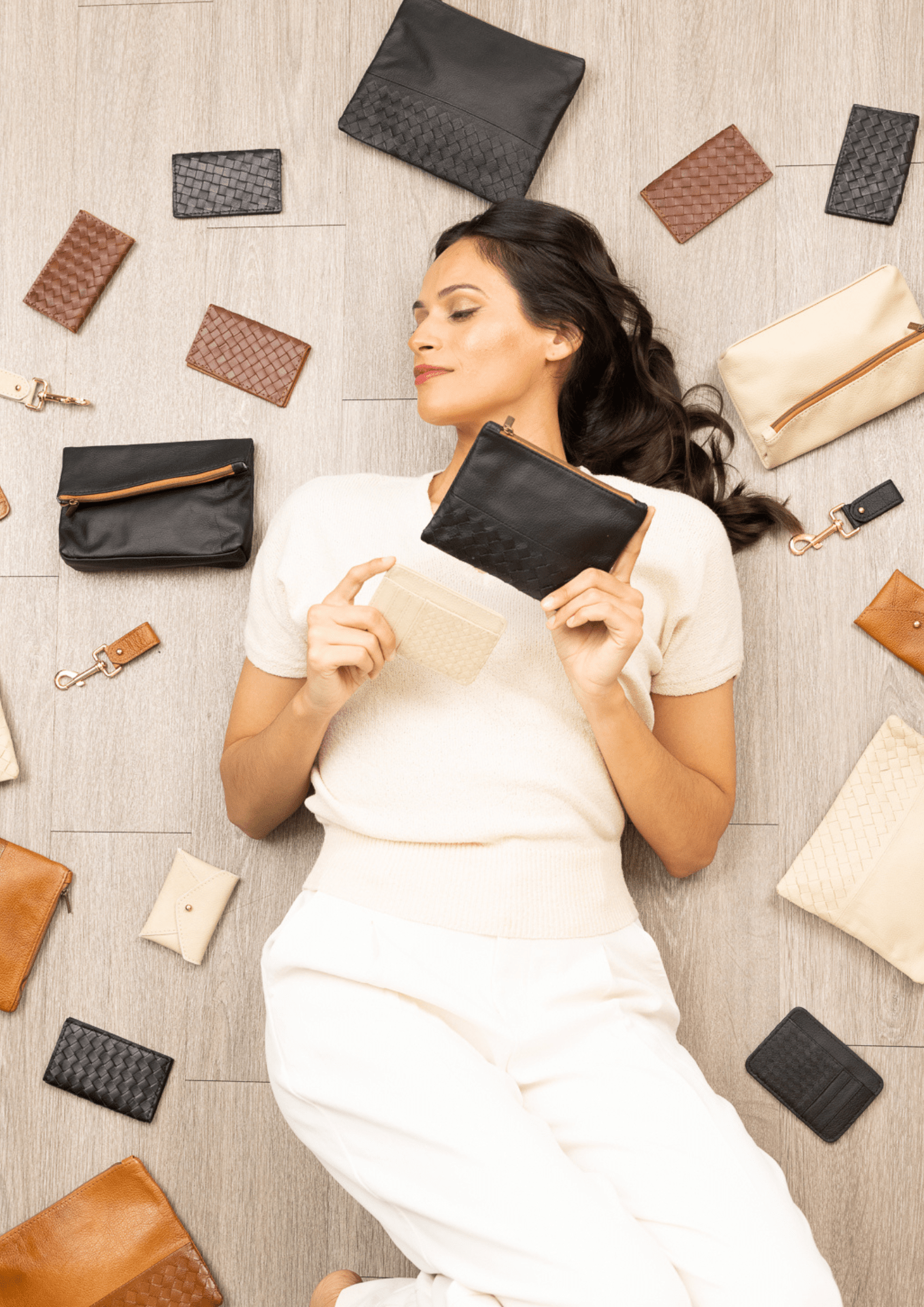 Woman lying on a floor surrounded by leather accessories