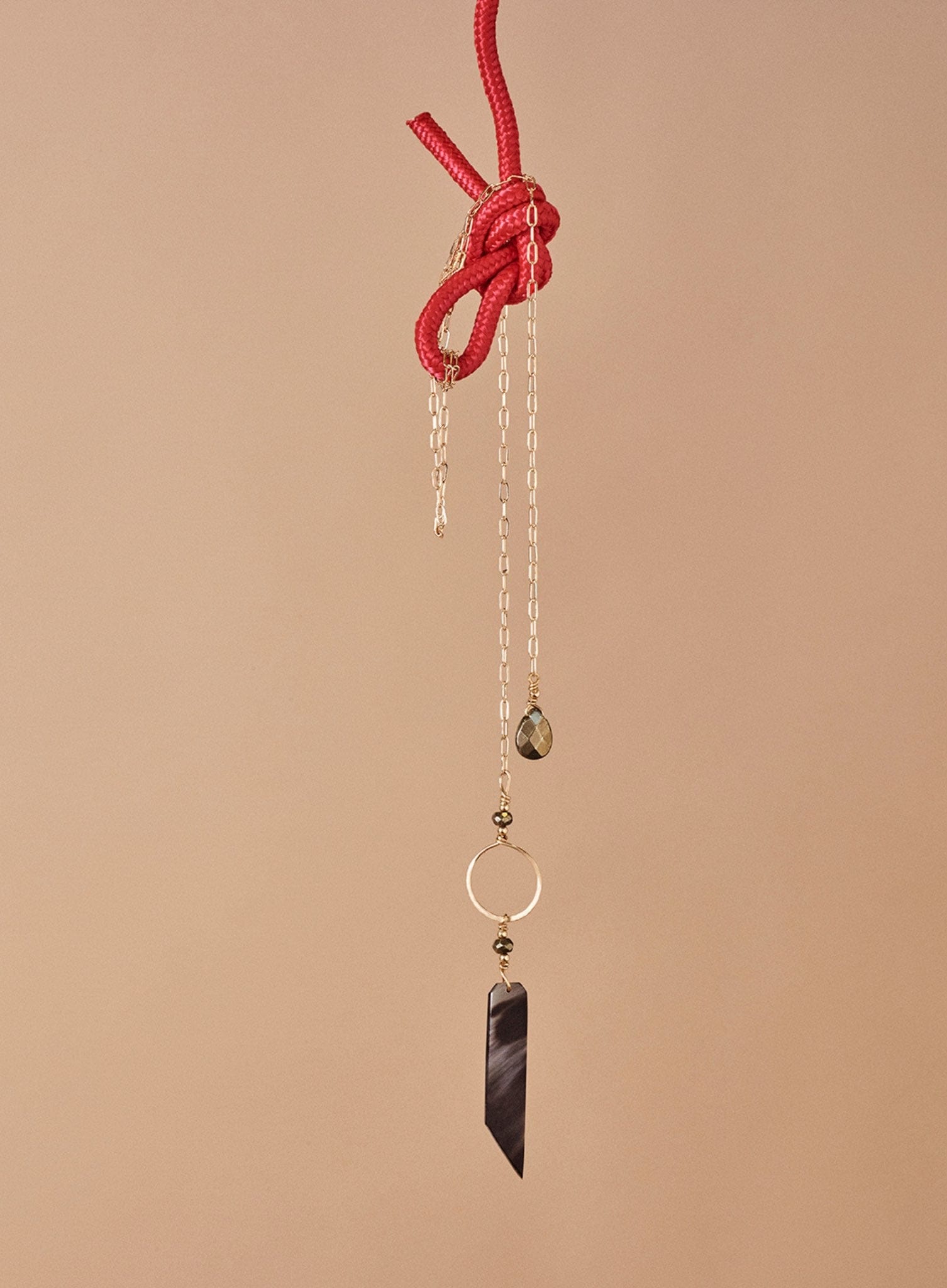 marcilia 18k gold long lariat on red rope.