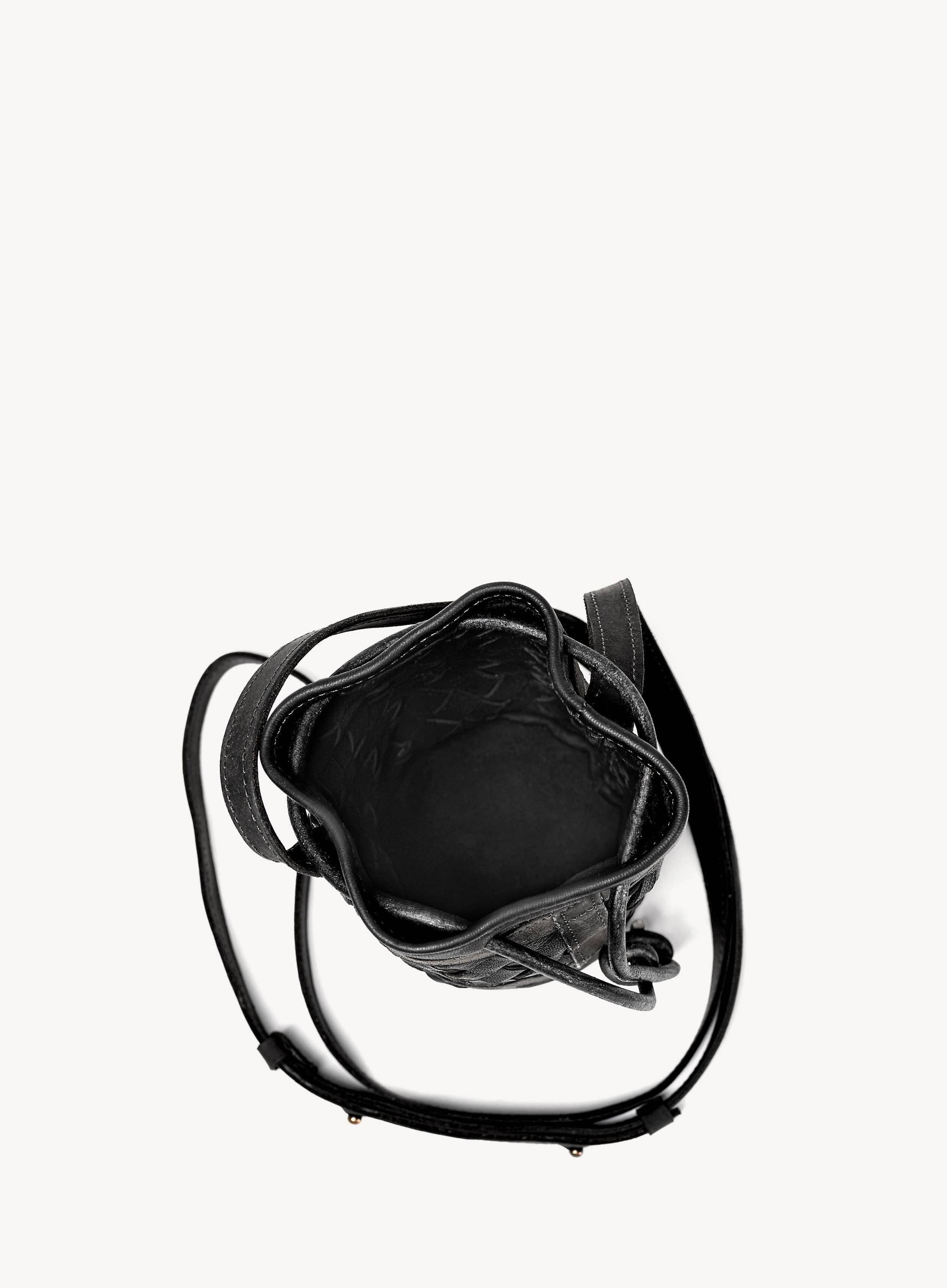Black handbag with a strap on a white background