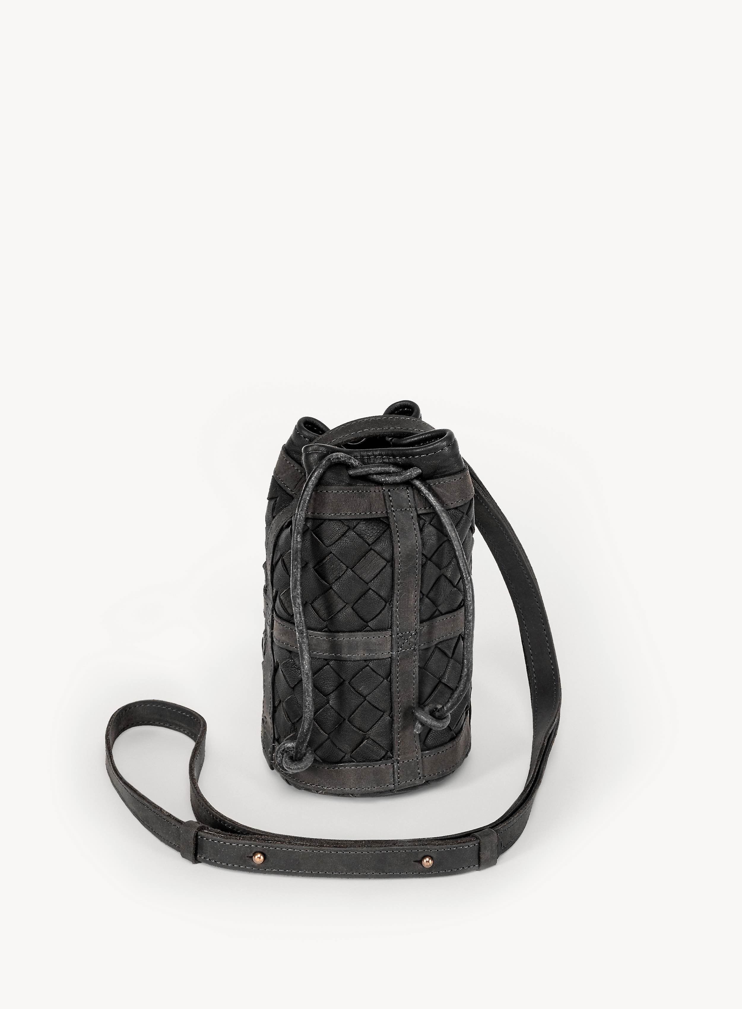 Black woven bag with a strap on a white background