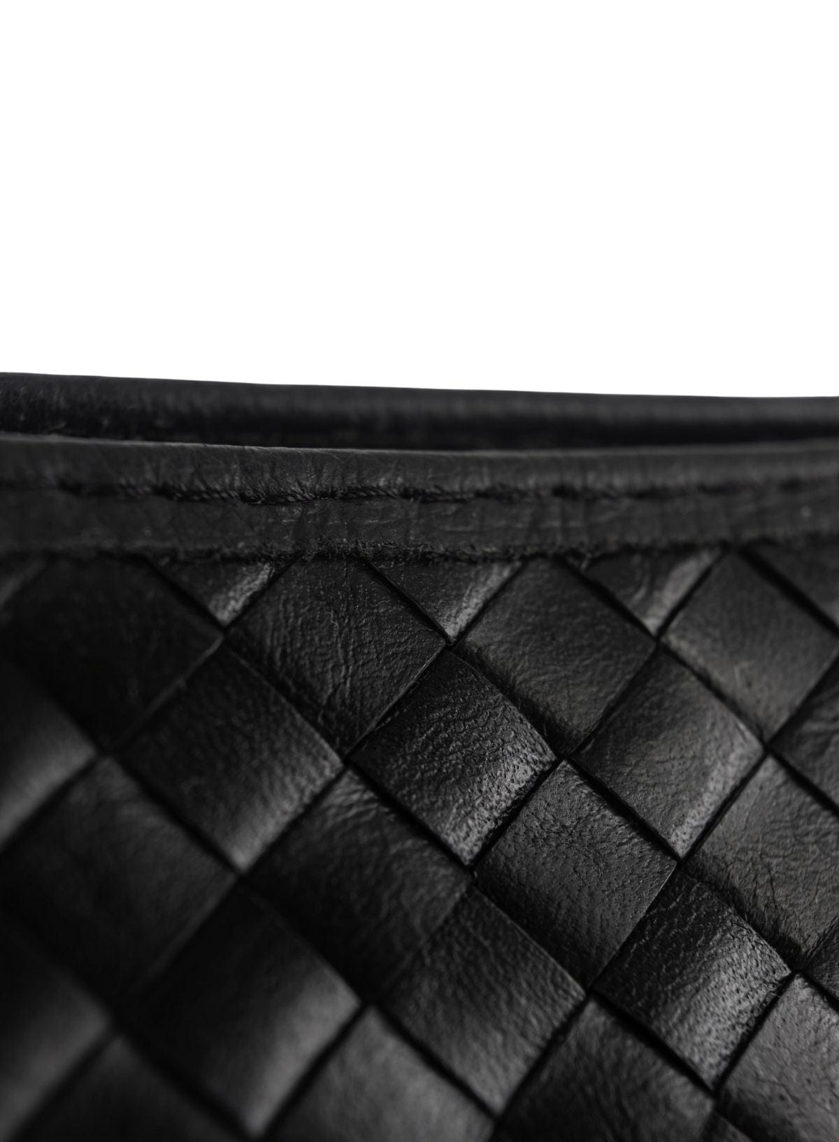 Close-up of a black woven leather clutch bag
