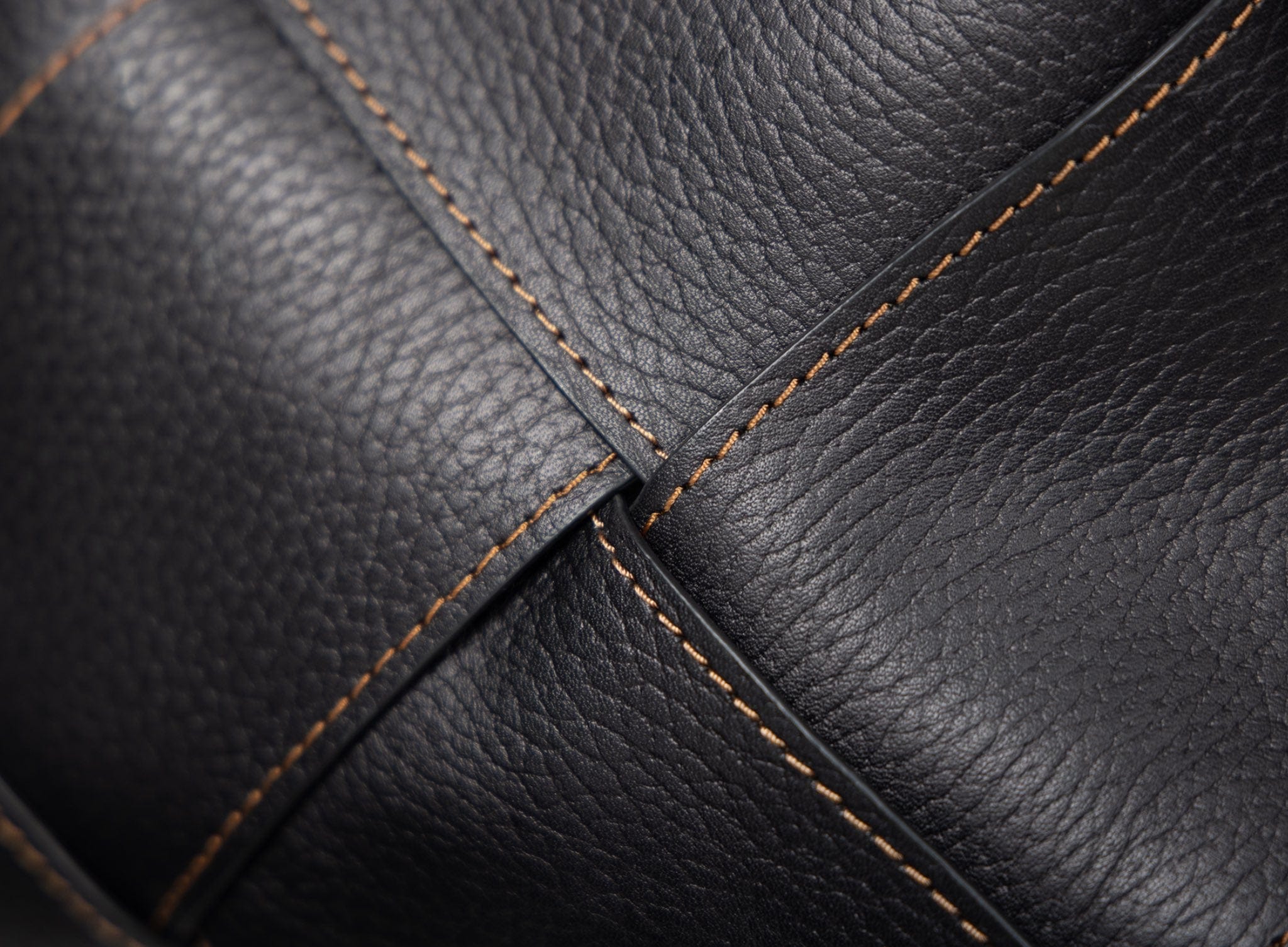 Close-up of black leather with brown stitching