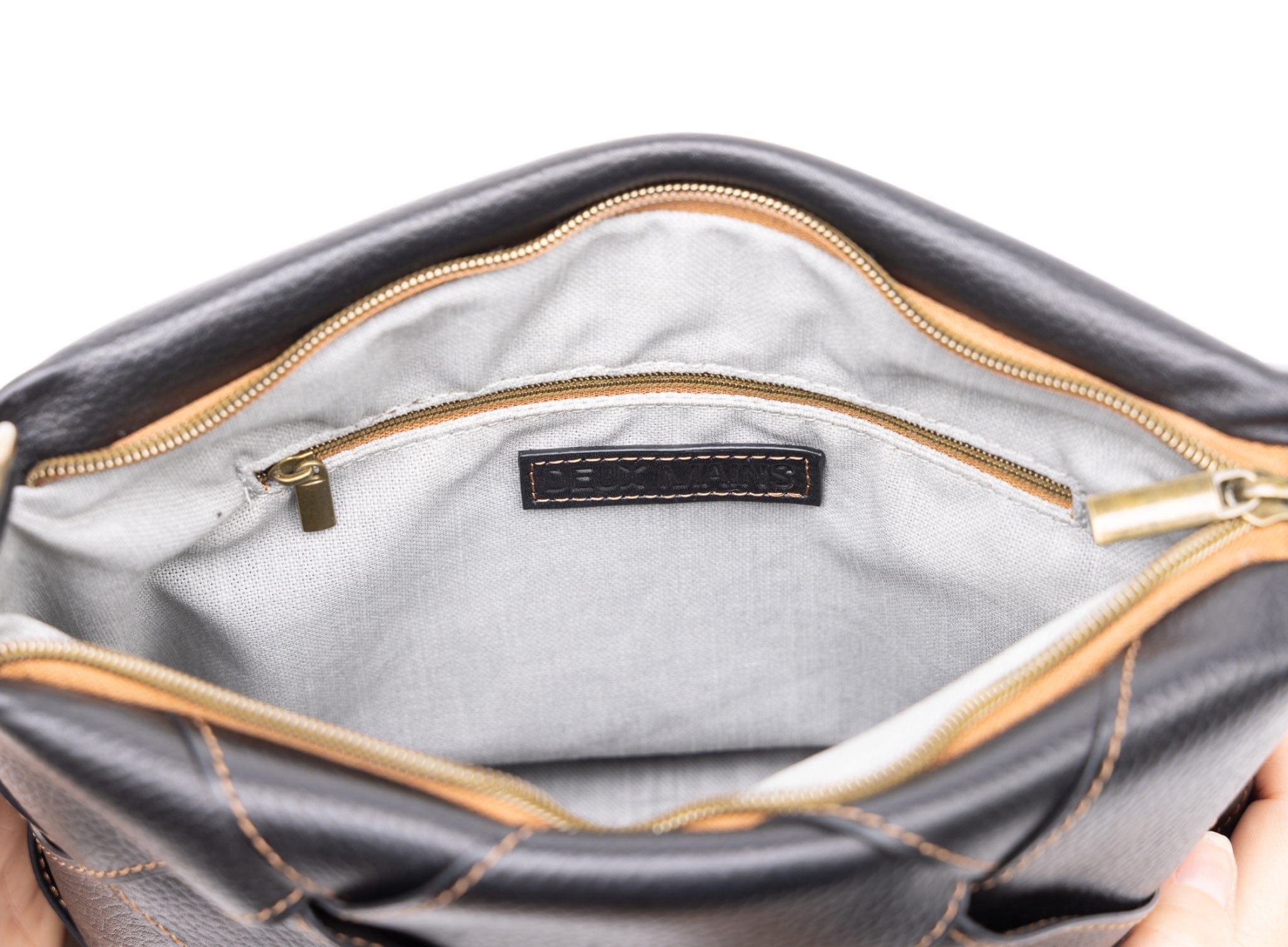 Close-up of a black handbag with zipper and interior lining.