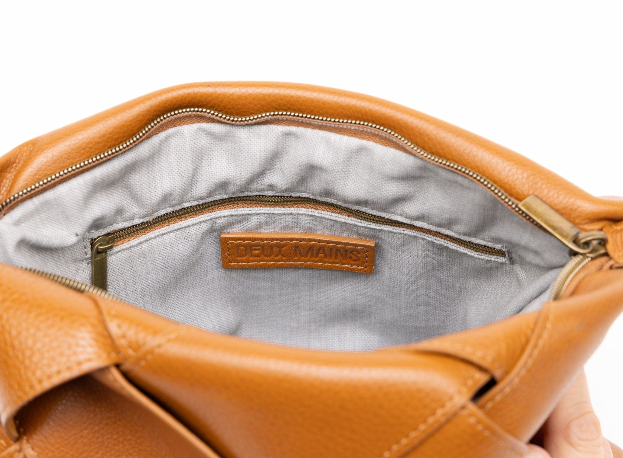 Honey leather handbag with visible brand name on a white background