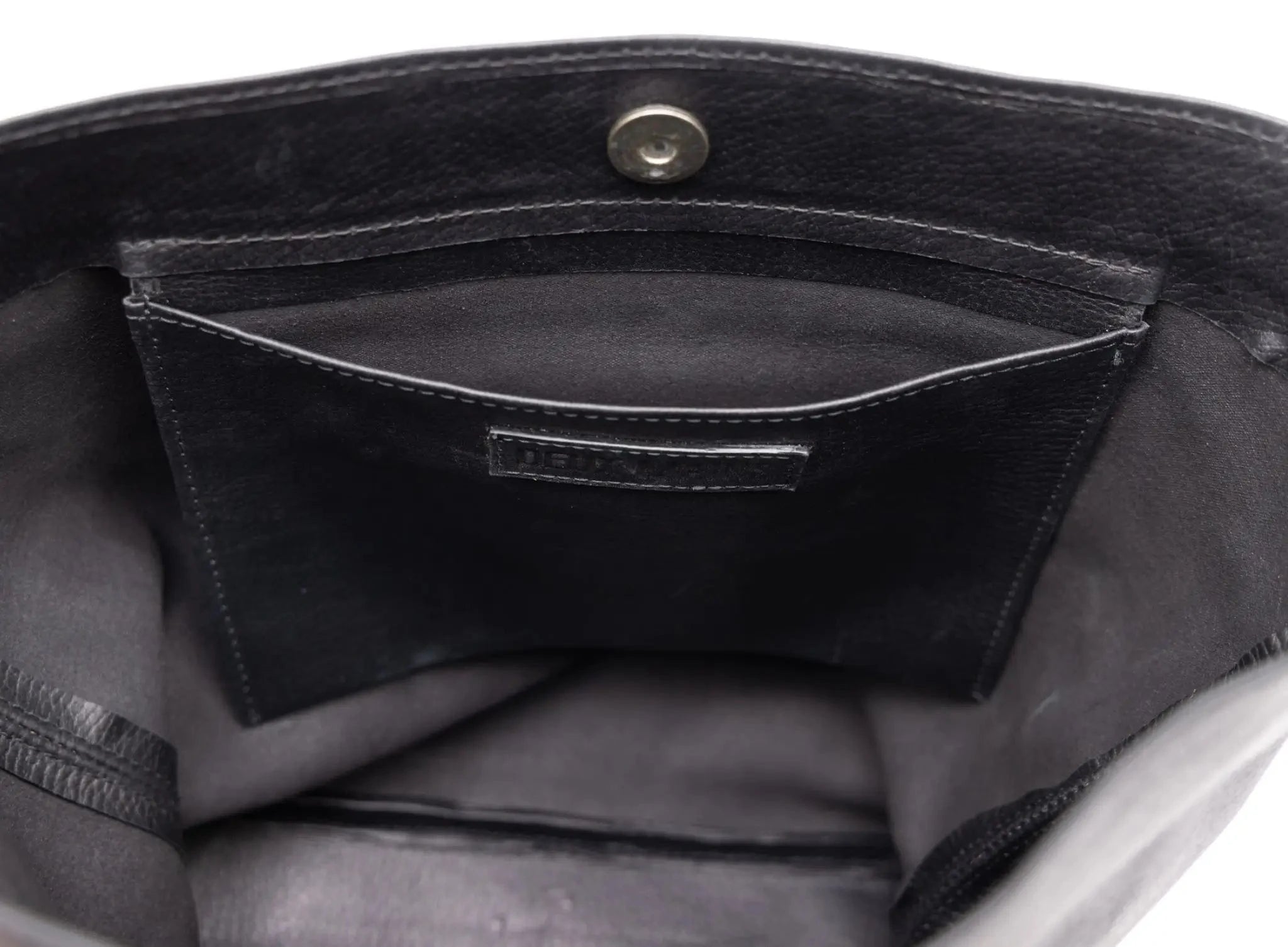 Close-up of a black leather bag with a visible brand logo.