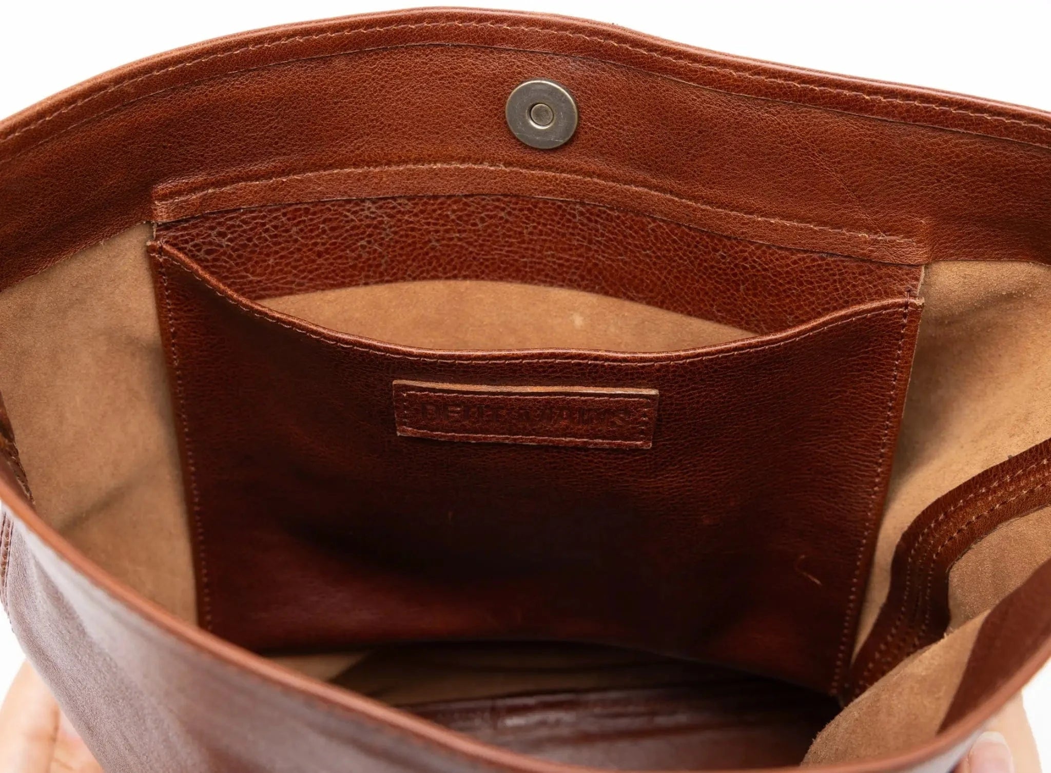Close-up of a brown leather bag with a visible brand label.