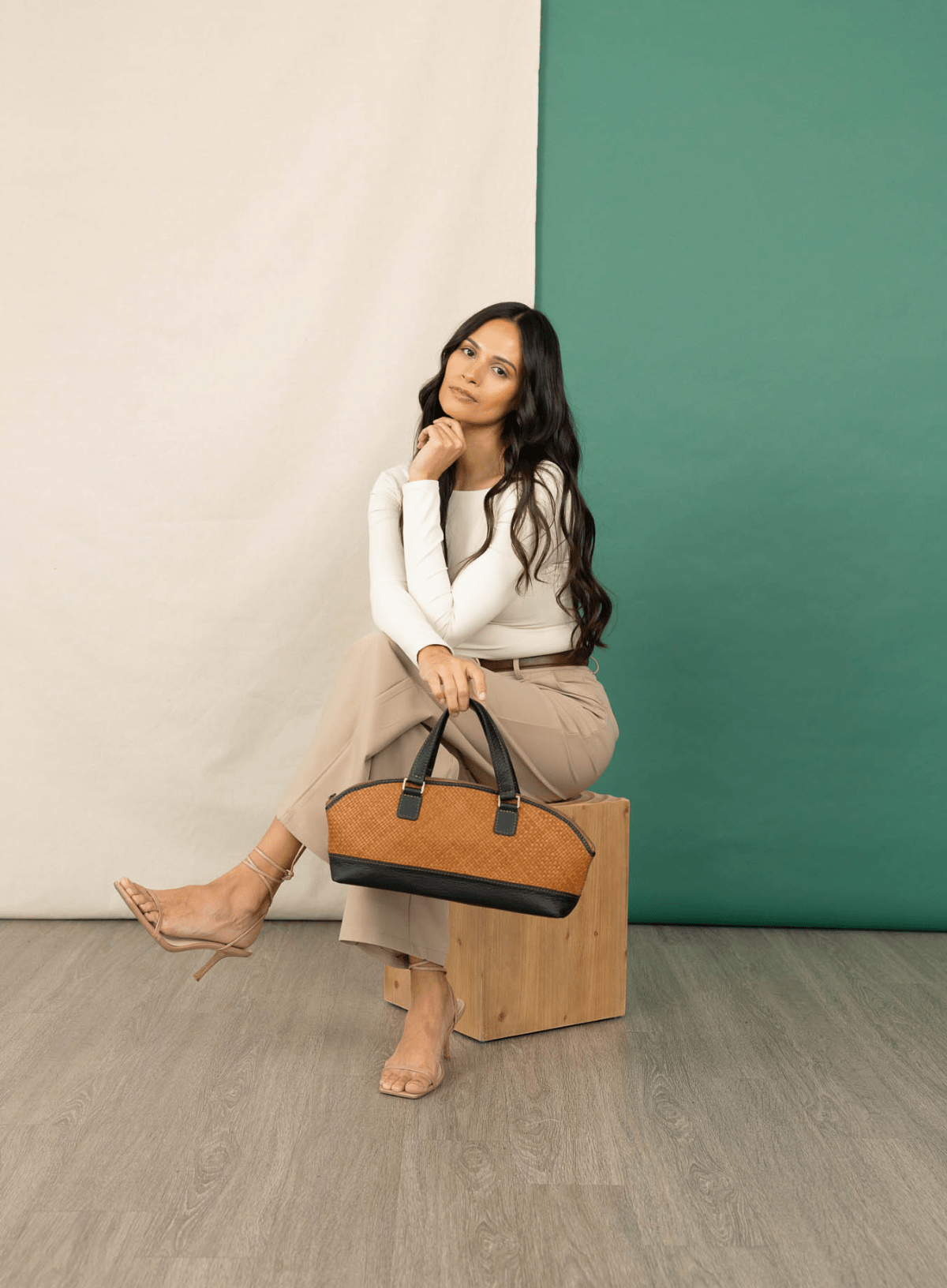 Satchel bowler bag held by model sitting