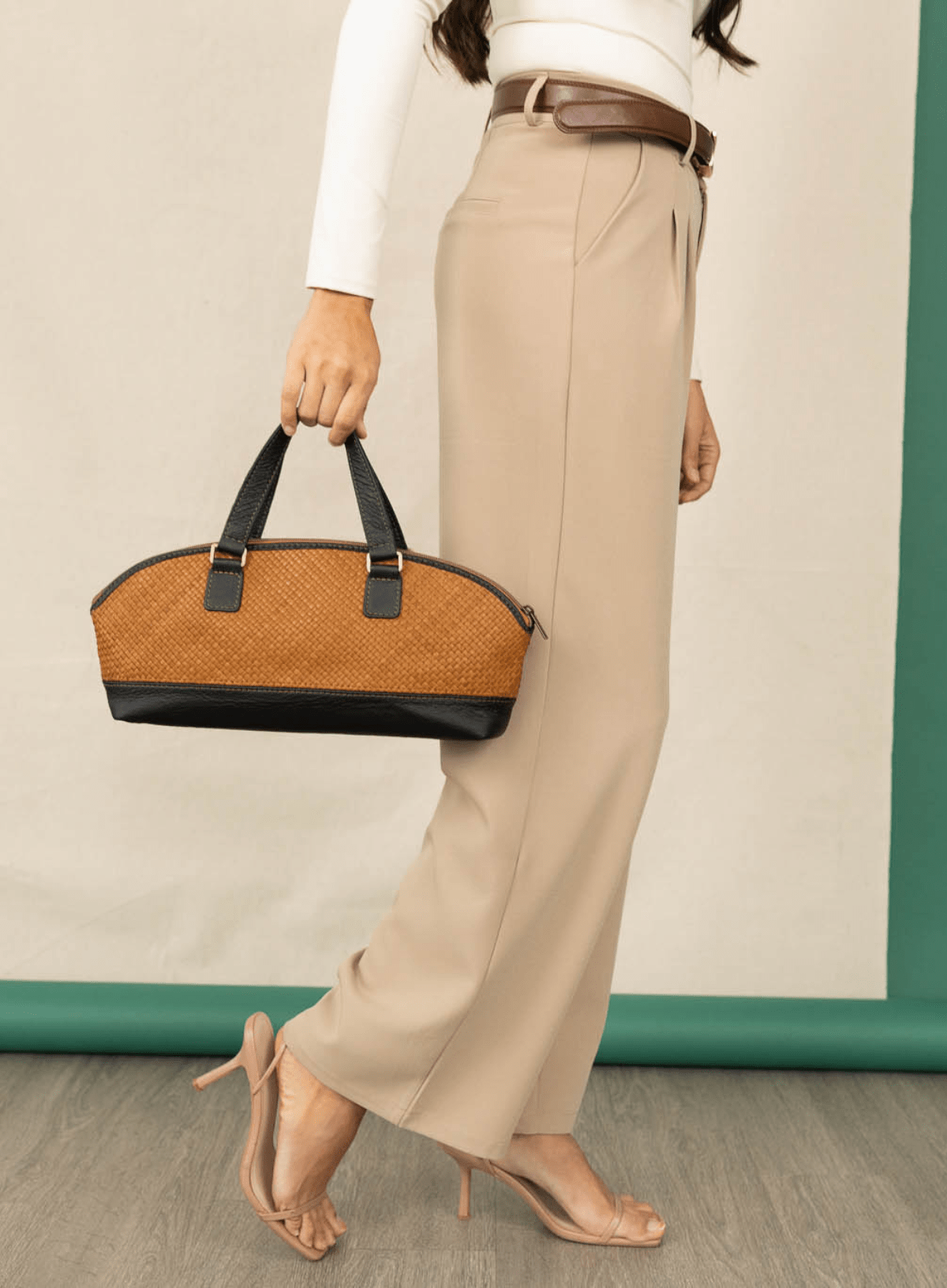 Satchel bowler bag held by model waling