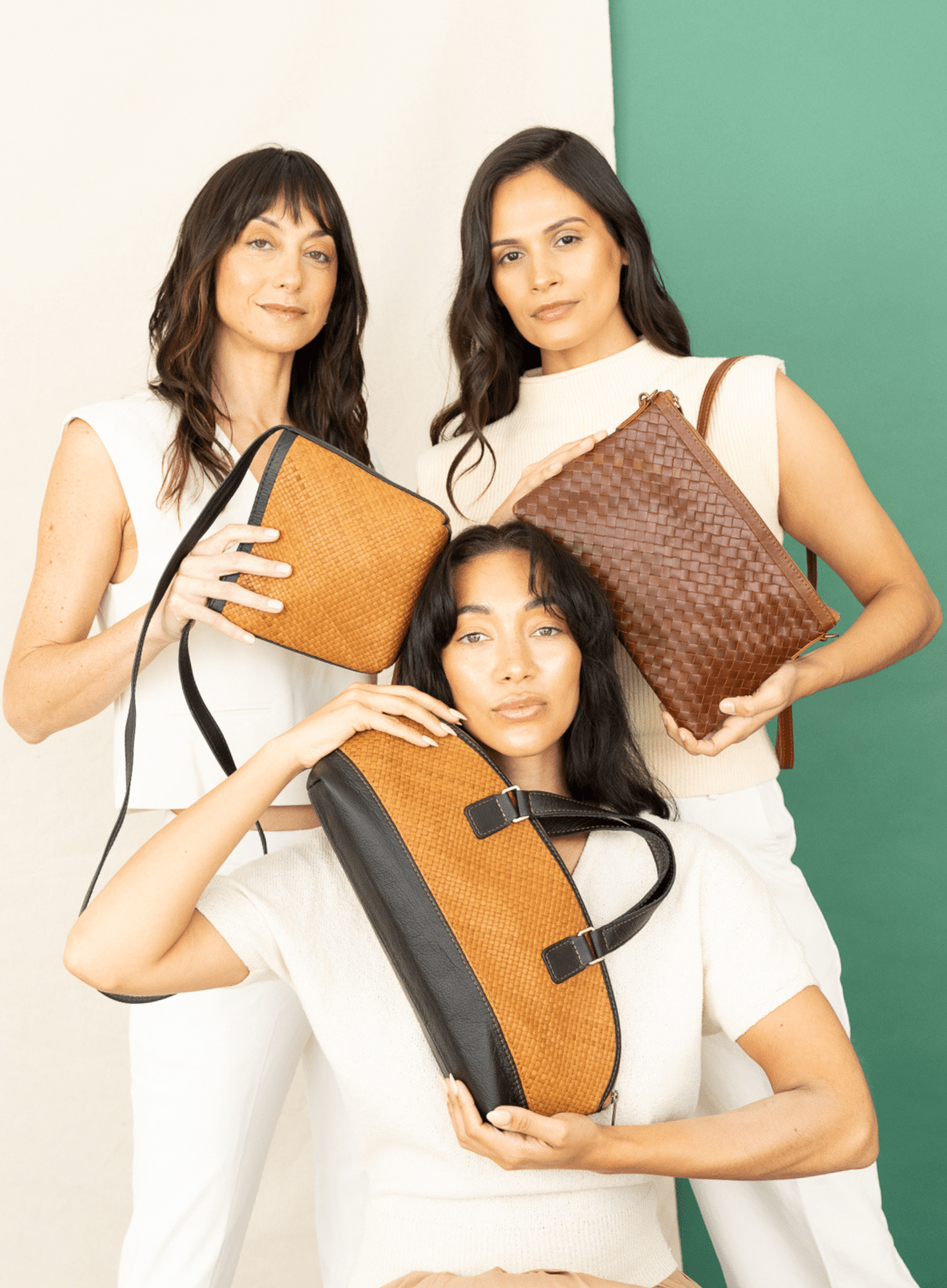Three women holding leather bags against a white and green background