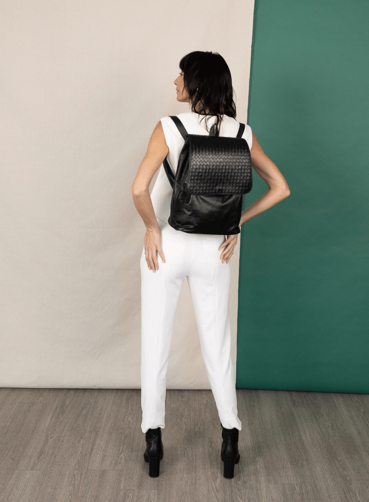 Model wearing the black leather woven backpack with from the spring collection.