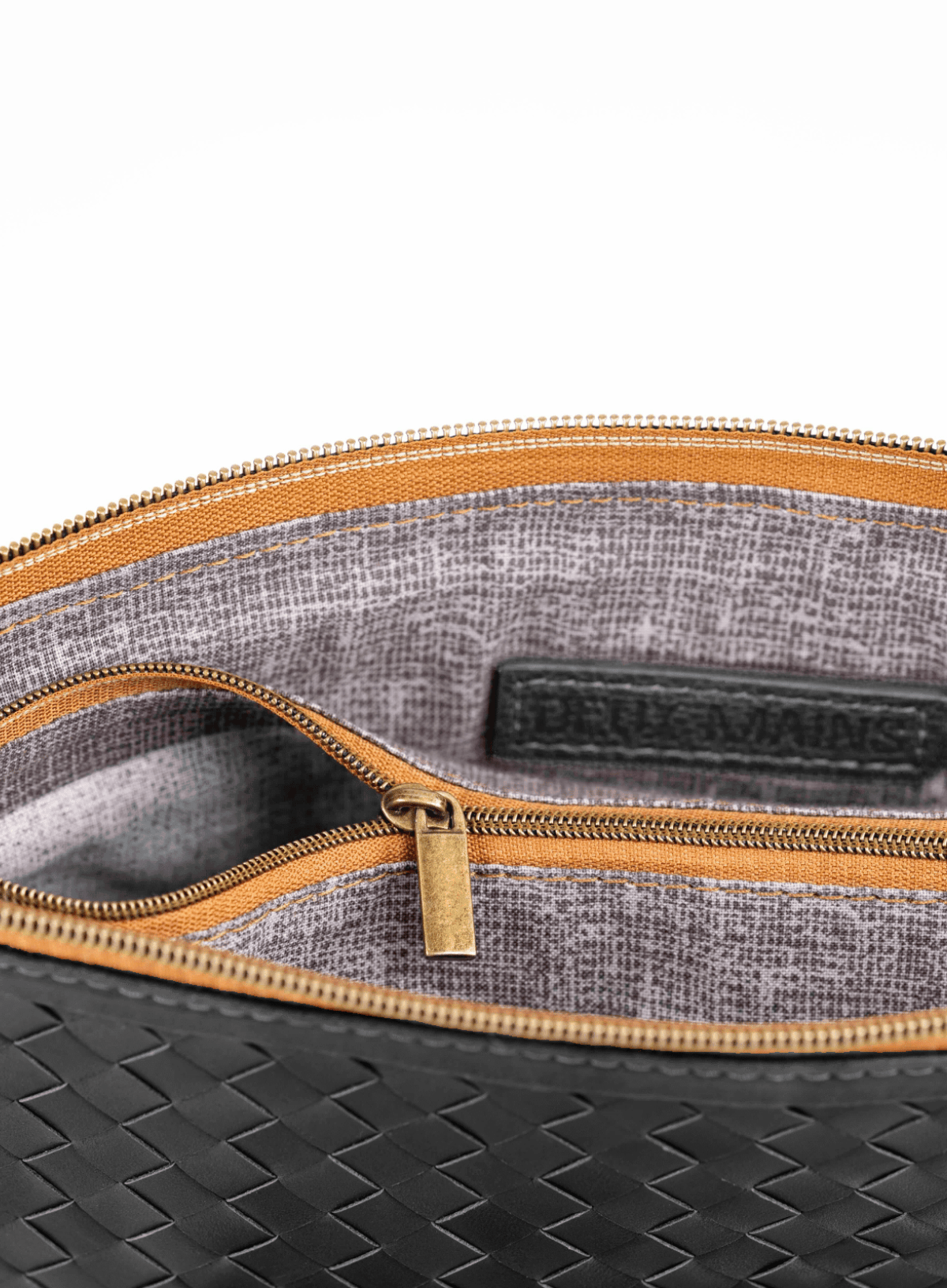 Close-up of a black and gray bag with a gold zipper on a white background