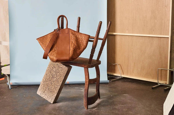 tote bag in cognac in studio with chair prop.