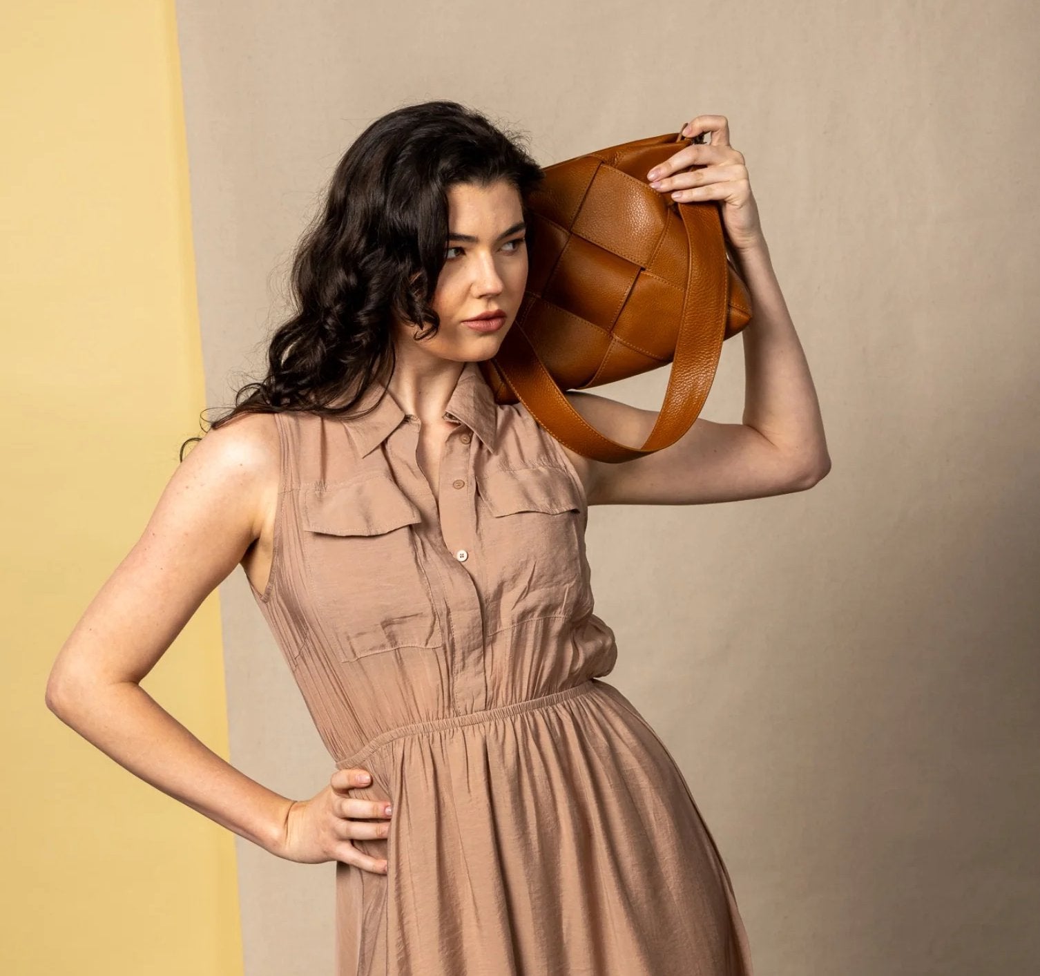 model holding the optimal shoulder bag in honey on her shoulder.
