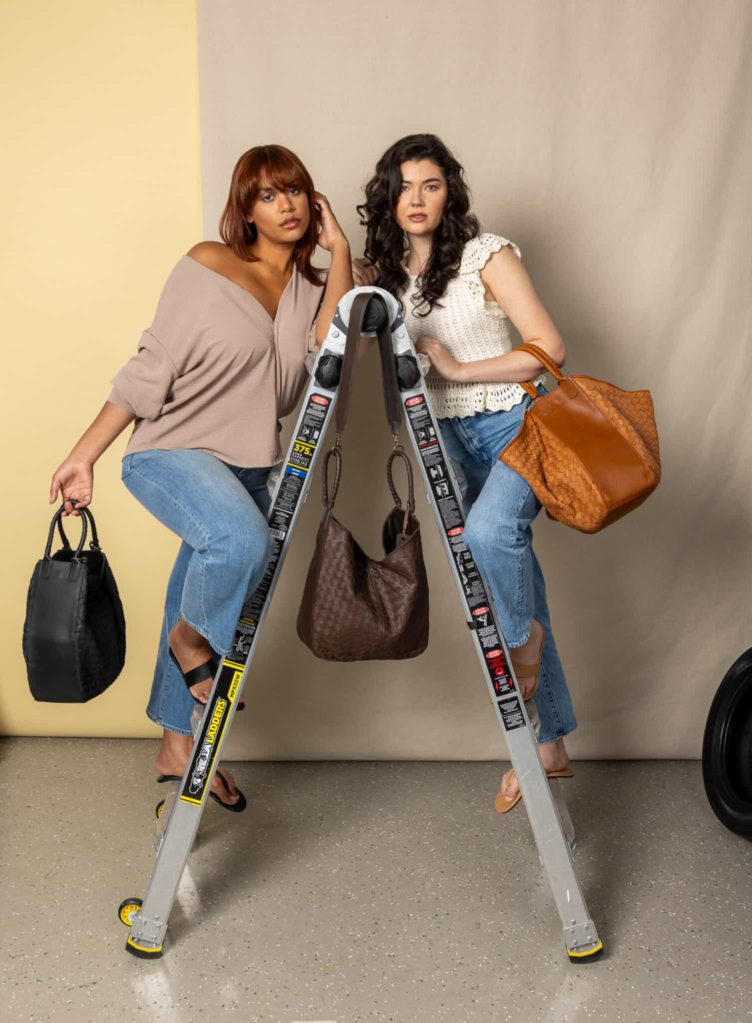 all day leather tote in black,brown and honey from womens together collection held by models on ladder.