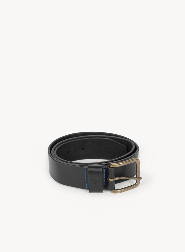 black leather belt with brass buckle and blue stitching curled up.