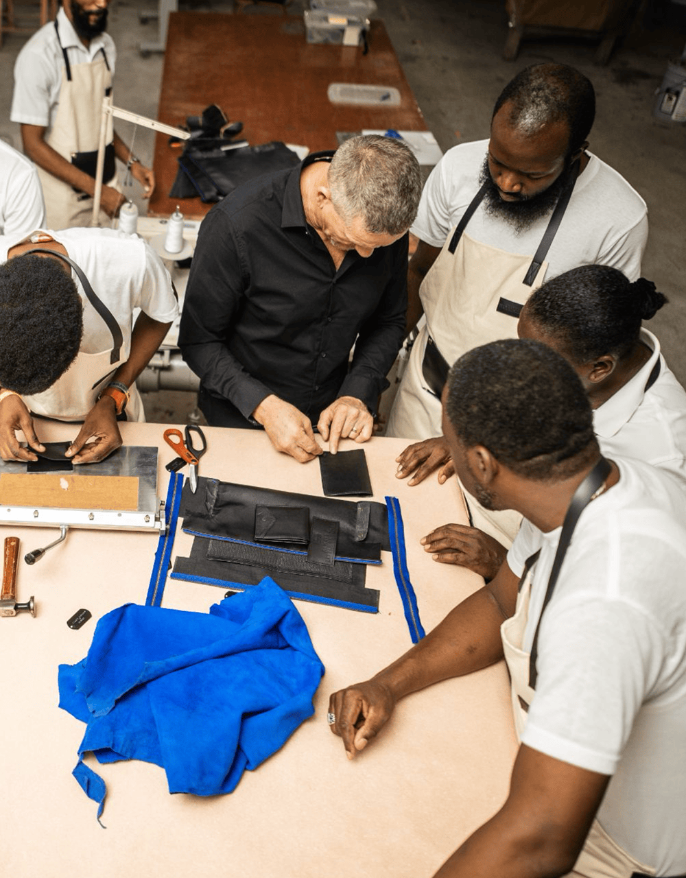 Group of people working together on a project at a table with tools and materials.