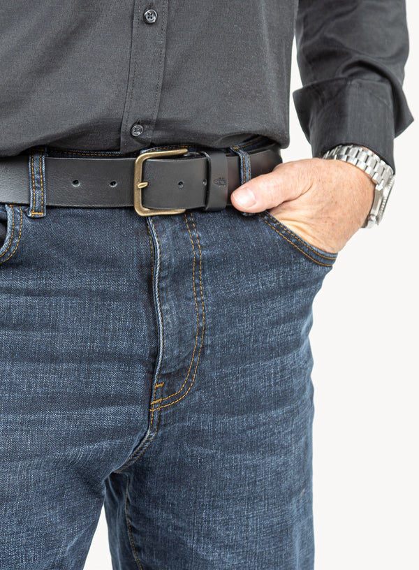 black leather belt with brass buckle and blue stitching showcased by model.
