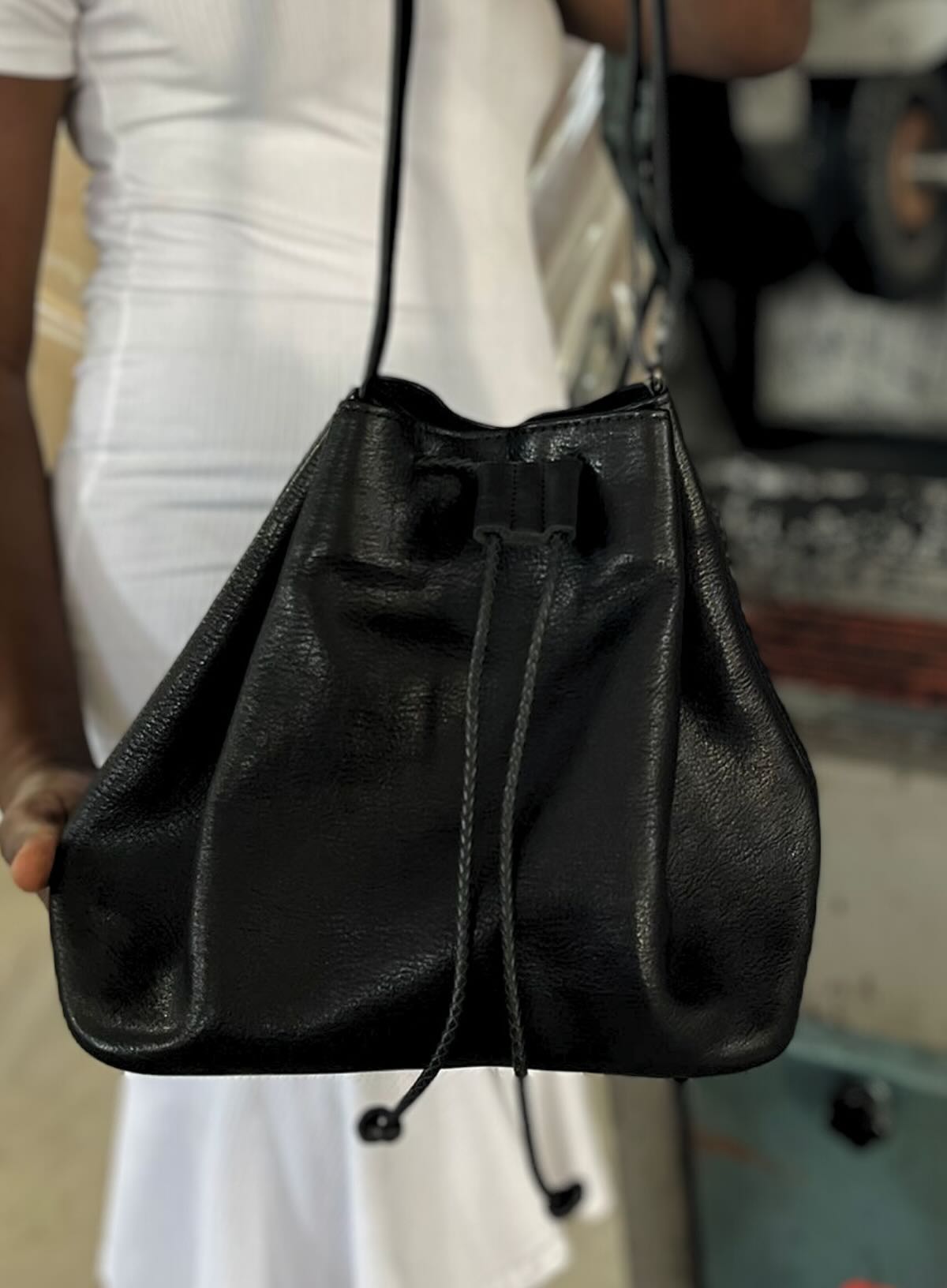 womens leather bucket bag in black from fall collection showcasing a close up by haitian artisan in our solar powered factory in haiti.