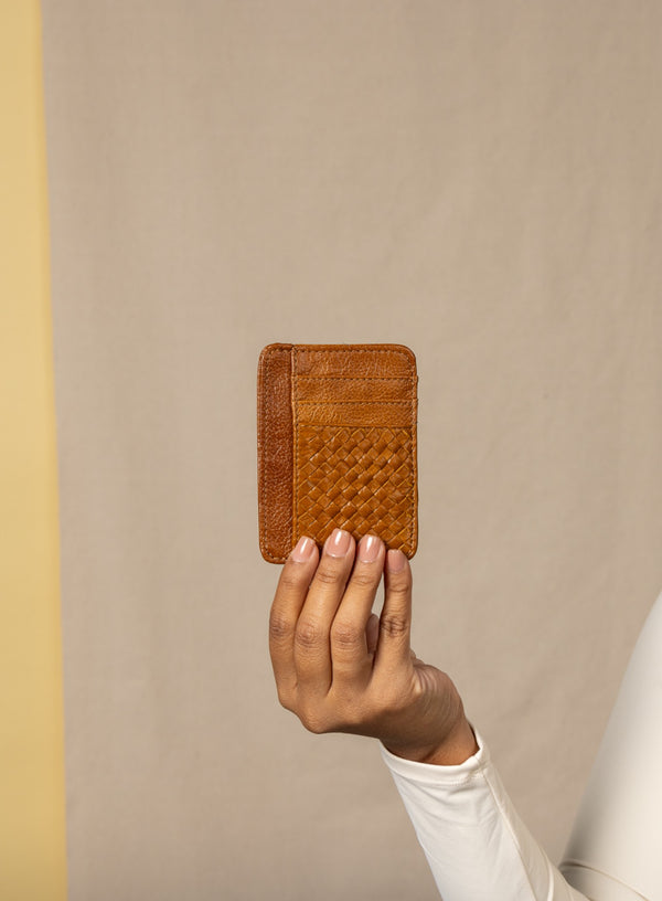 card holder in cognac from ethically crafted accessories held by model showcasing front view.