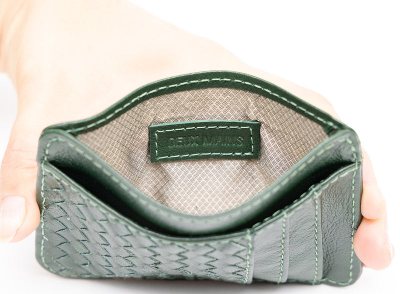 card holder in green from ethically crafted accessories held by model showcasing interior view.