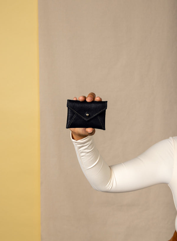 coin pouch from ethically crafted accessories in black color held by model showcasing front view.