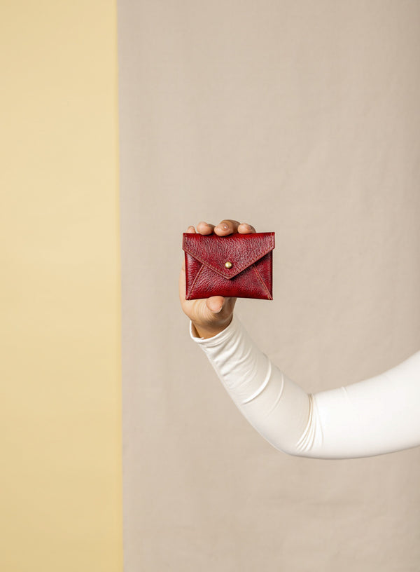 coin pouch from ethically crafted accessories in bordeaux color held by model showcasing front view.