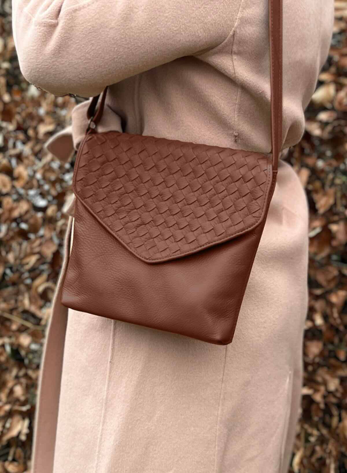 envelope crossbody in brown from spring and summer collection in front of nature..