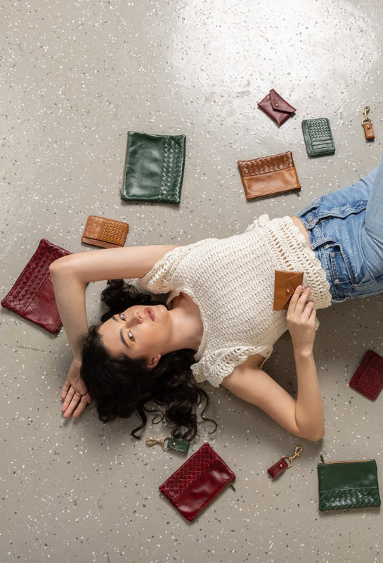 model lying on the floor surrounded by a collection of autumn accessories, showcasing sustainable seasonal fashion trends and styles.