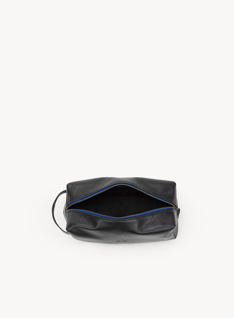 iron tight toiletry bag in black showcasing blue stitching and handle interior-view.