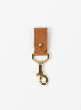 key chain for christmas present from ethically crafted accessories in cognac color leather and gold coated metal showcasing front view. 