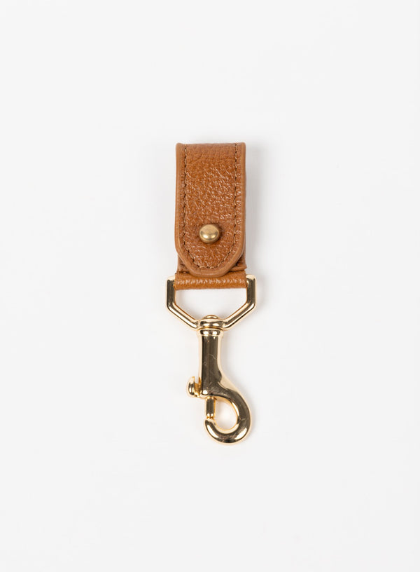 key chain from our ethically crafted accessories in cognac color leather and gold coated metal showcasing front view. 