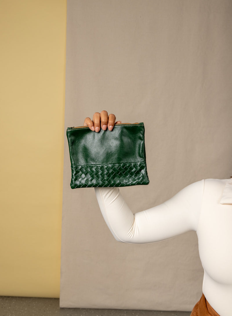    large pouch from ethically crafted accessories in green held by model showcasing front view.