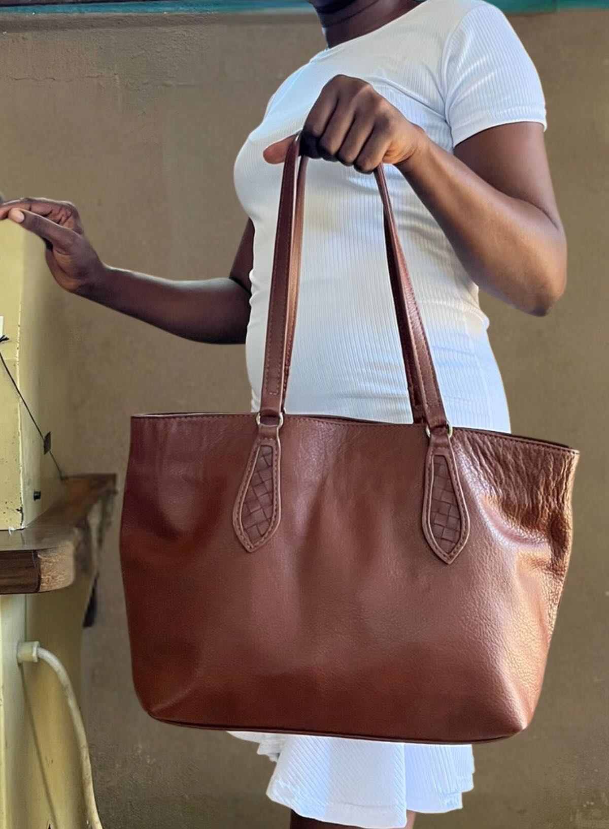 womens leather mid tote in brown from the fall collection showcased by haitian artisan in solar powered factory in haiti.