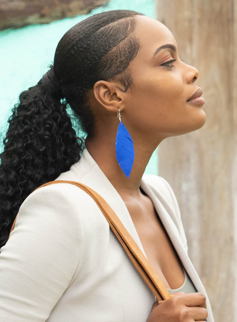 sterling silver and leather feather earrings in blue worn by model showcasing intricate details.